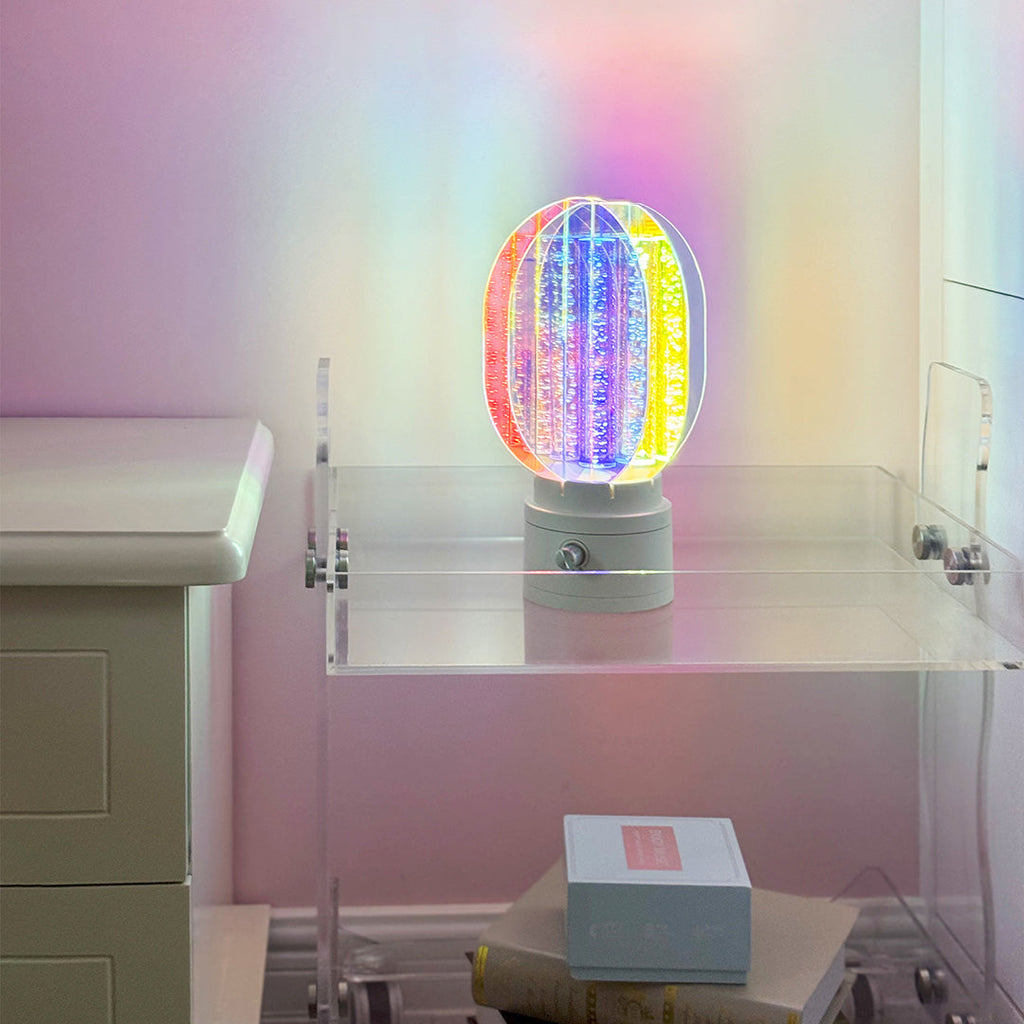1. "VIVIENNE RAINBOW METAL TABLE LAMP"  
   A vibrant blend of colors and artistic design, this aluminum table lamp radiates warmth and creativity with its unique LED illumination.

2. "HAMPSTEAD ARTISANAL RAINBOW LAMP"  
   A striking fusion of color and