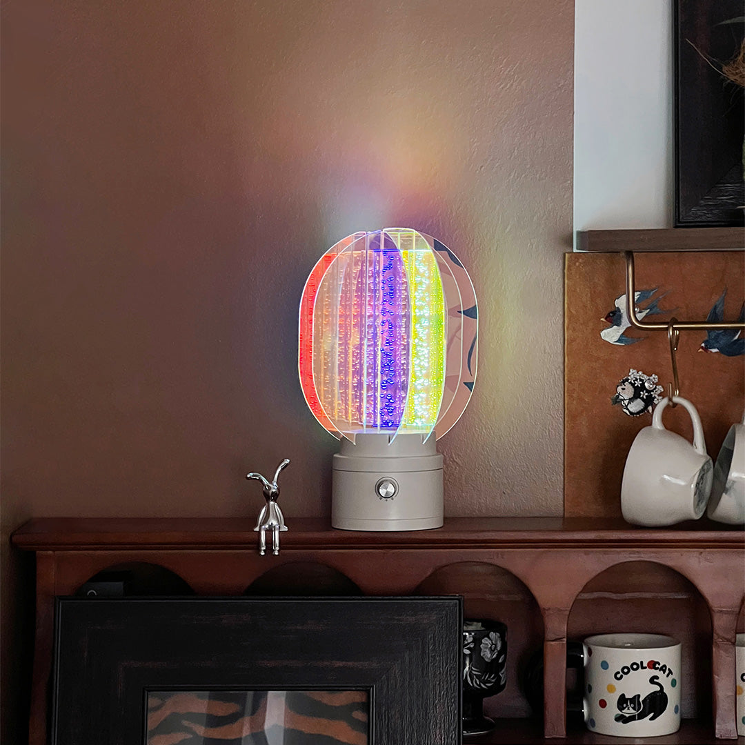 1. "VIVIENNE RAINBOW METAL TABLE LAMP"  
   A vibrant blend of colors and artistic design, this aluminum table lamp radiates warmth and creativity with its unique LED illumination.

2. "HAMPSTEAD ARTISANAL RAINBOW LAMP"  
   A striking fusion of color and