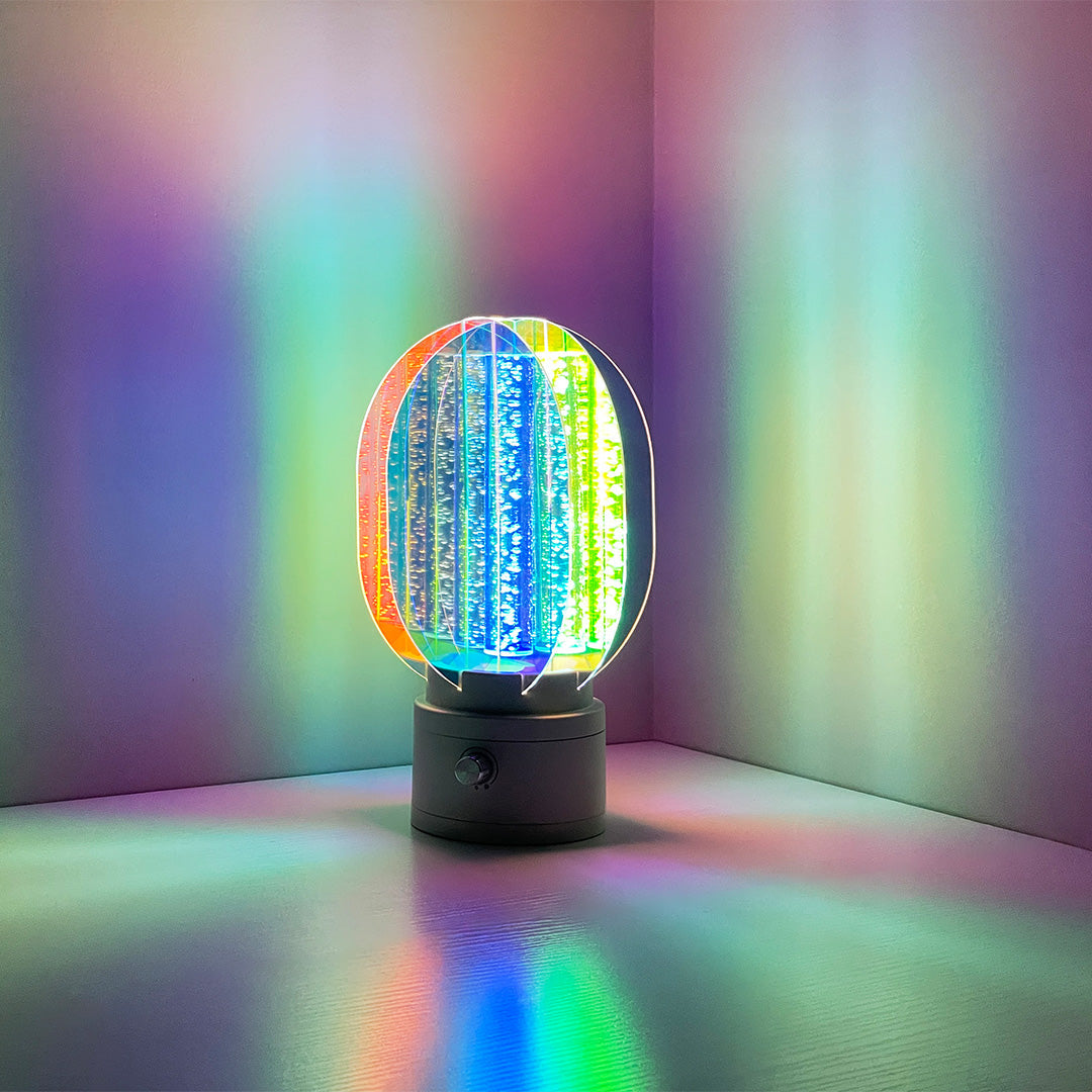 1. "VIVIENNE RAINBOW METAL TABLE LAMP"  
   A vibrant blend of colors and artistic design, this aluminum table lamp radiates warmth and creativity with its unique LED illumination.

2. "HAMPSTEAD ARTISANAL RAINBOW LAMP"  
   A striking fusion of color and